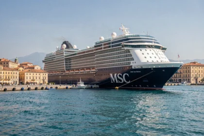 Paquebot MSC en déstockage amarré dans un port méditerranéen avec architecture historique en arrière-plan